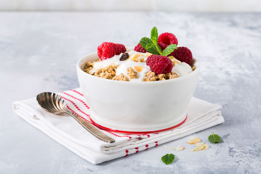 A white bowl filled with oatmeal and fresh berries.