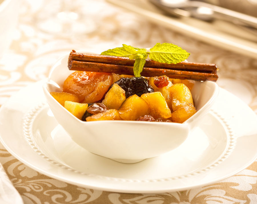 Hot Fruit Compote, a bowl of cooked fruit topped with a cinnamon stick