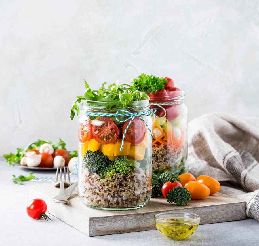 A mason jar filled with healthy salad ingredients.