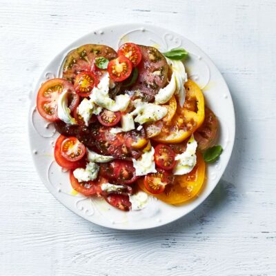 A plate of tomatoes with mozzarella cheese on top.