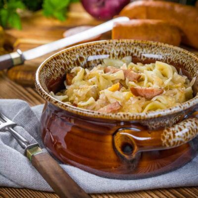 A bowl of pasta with sauerkraut and bacon
