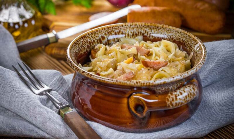 A bowl of pasta with sauerkraut and bacon