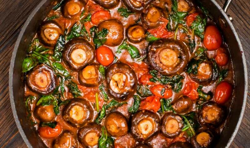 Mushrooms with tomatoes and spinach in a skillet