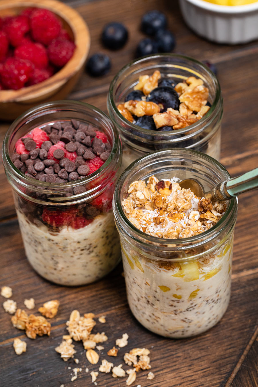 Overnight oats with toppings like raspberries, chocolate chips, granola, blueberries, and granola
