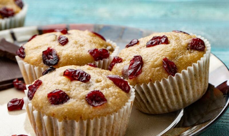 Cherry Oat muffins on a plate with cherries on the side.